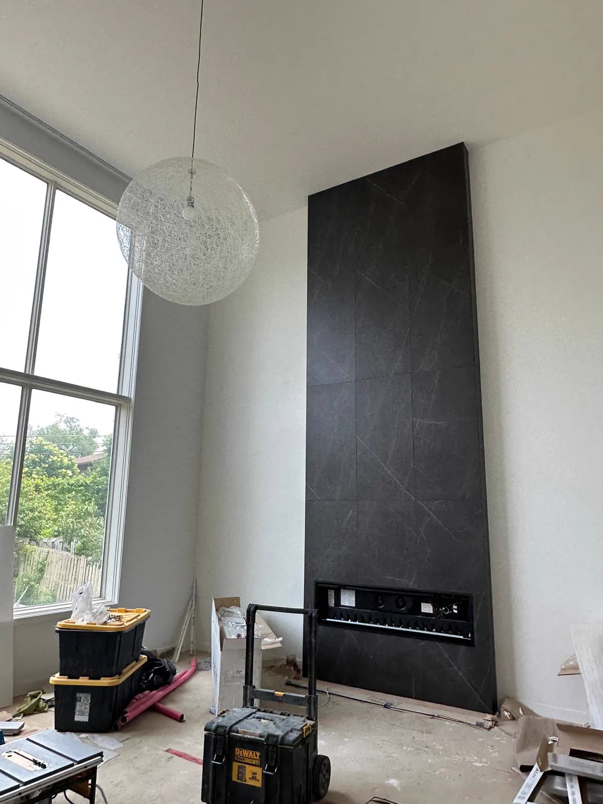 Mur décoratif noir avec foyer encastré en cours d’installation