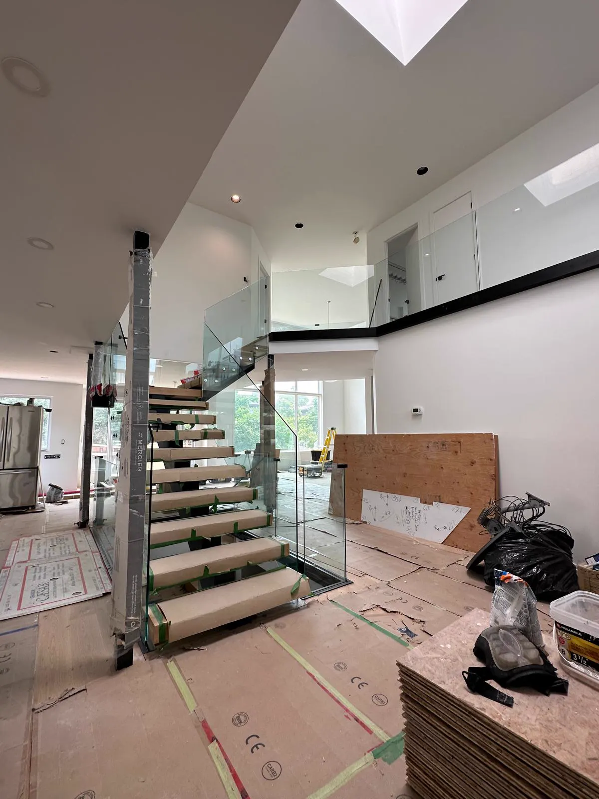 Escalier flottant avec garde-corps de verre pendant les travaux