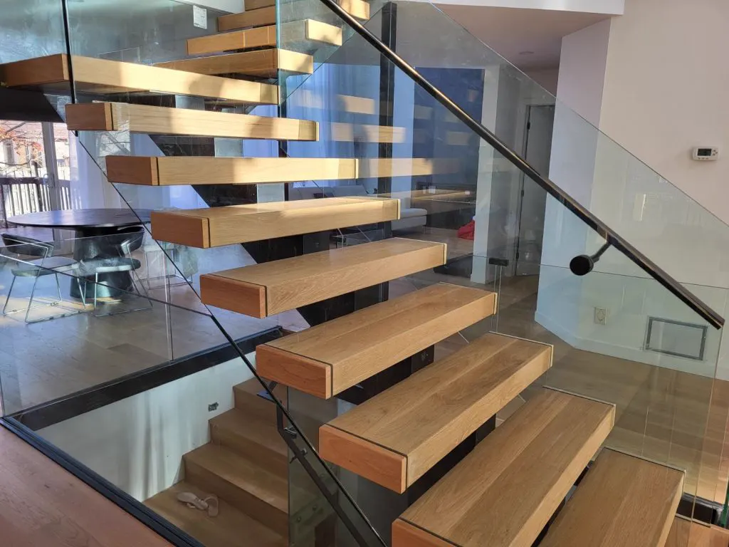 Escalier en bois aux marches flottantes et garde-corps de verre, exemple de réalisation des Constructions R.B.J